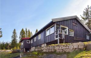 a black house on top of a stone wall at Nice Home In Heggedal With Wifi And 4 Bedrooms 