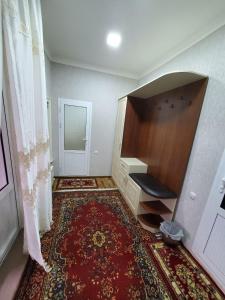 an empty room with a desk and a rug at Nursultan Grand Guest House in Samarkand