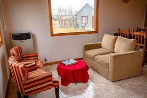 sala de estar con sofá, 2 sillas y mesa en Cabañas Las Cumbres en El Calafate