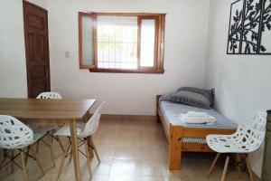 een kamer met een tafel en een bed en een tafel en stoelen bij Alquiler por dia Departamento 3 personas Gral Roca Casita Artigas in General Roca