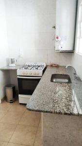 a kitchen with a stove and a counter top at Alquiler por dia Departamento 3 personas Gral Roca Casita Artigas in General Roca