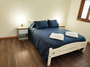 een slaapkamer met een bed met twee handdoeken erop bij Alquiler por dia Departamento 3 personas Gral Roca Casita Artigas in General Roca