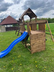 a wooden playset with a slide and a playground at Noclegi Dąbek in Rymanów