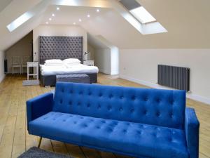 a blue couch and a bed in a room at Home Farm - The Dairy -uk34626 in Dunragit