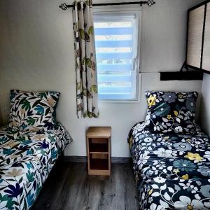 Habitación pequeña con 2 camas y ventana en Mammiehome - 6 places - Mimizan - Camping La Lande en Mimizan
