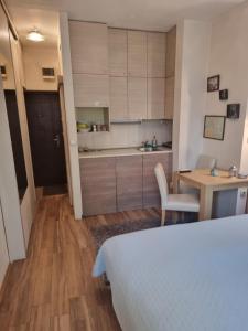sypialnia z łóżkiem i stołem oraz kuchnia w obiekcie Apartment Bombonjera w mieście Užice