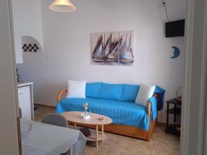 a living room with a blue couch and a table at Logaras Seaview Apartment in Logaras