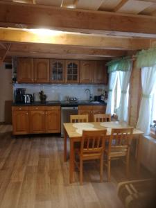 a kitchen with wooden cabinets and a table and chairs at U Toma in Malá Morávka