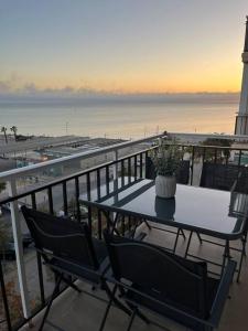 a table and chairs on a balcony with a view of the beach at Apartamento con preciosas vistas a pie de playa in Santa Pola