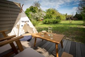 a wooden table on a deck with a tent at Domek Mikołajki in Mikołajki