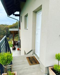 a porch with a door with a welcome mat on it at Ivekova klet, kuća za odmor in Ključić Brdo