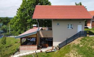 a small house with an orange roof on a hill at Ivekova klet, kuća za odmor in Ključić Brdo