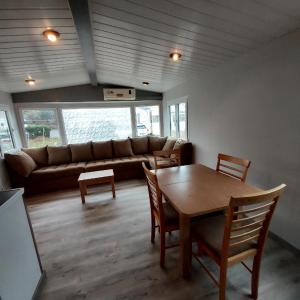 sala de estar con sofá, mesa y sillas en Mammiehome - 6 places - Mimizan - Camping La Lande en Mimizan