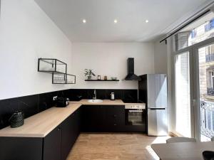 eine Küche mit Kühlschrank und Spüle in der Unterkunft T2 balcon Hyper centre - Paradis in Marseille