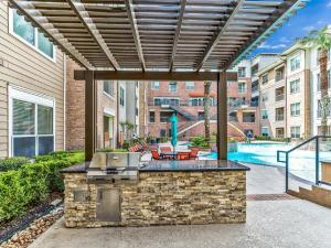 a patio with a grill and a pool in a building at Elegant 2BR Ideal for Long Term Stay in Houston
