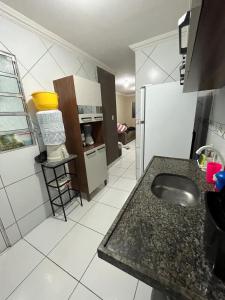 a kitchen with a sink and a refrigerator at Apartamento muito aconchegante in Paulista +2 photos