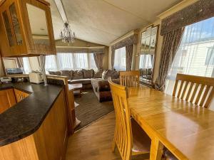 a kitchen and living room with a wooden dining table at 6 Berth Caravan Nearby Hunstanton Beach Front In Norfolk Ref 13019l in Hunstanton