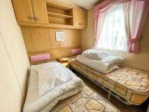 two beds in a small room with a window at 6 Berth Caravan Nearby Hunstanton Beach Front In Norfolk Ref 13019l in Hunstanton