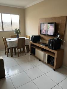 a living room with a television and a dining room table at Apartamento muito aconchegante in Paulista +2 photos