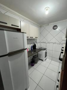 a white kitchen with a refrigerator and a counter at Apartamento muito aconchegante in Paulista