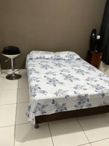 a bed with a blue and white comforter on it at Apartamento muito aconchegante in Paulista