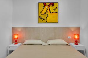 a bedroom with a bed with two tables and a picture of a chicken at STUNNING HOLIDAYS, Large Terrace On The Sea in El Guincho