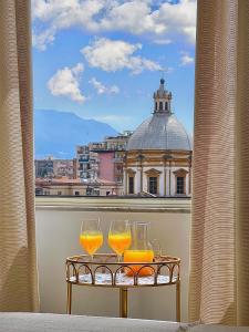 dwie szklanki soku pomarańczowego na stole na balkonie w obiekcie Stella di Ballaro w mieście Palermo