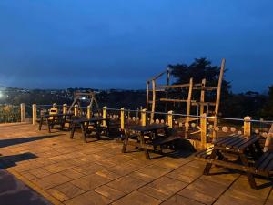 un grupo de mesas y bancos de madera en un patio en 3 bed luxury lodge at Hoburne Devon Bay en Goodrington