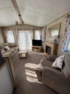 a large living room with couches and a television at 3 bed luxury lodge at Hoburne Devon Bay in Goodrington