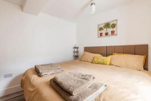 a bedroom with a large bed with towels on it at Comfortable flat close to the beach in Brighton & Hove