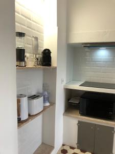 a kitchen with white cabinets and a black microwave at Angels Homes-n27, 3ºfloor - Bairro Típico, Centro Lisboa in Lisbon