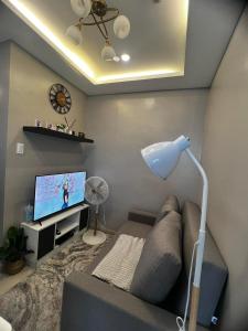 sala de estar con sofá y TV de pantalla plana en Victoria Sports Tawer en Manila