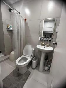a bathroom with a toilet and a sink at Victoria Sports Tawer in Manila
