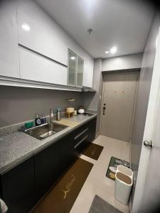 eine kleine Küche mit einem Waschbecken und einer Tür in der Unterkunft Victoria Sports Tawer in Manila