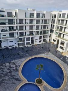 un grand immeuble avec un palmier au milieu dans l'établissement Appartement de luxe sur agadir bay, à Agadir