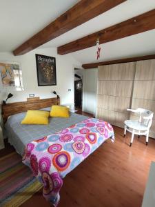 a bedroom with a large bed and a chair at la bottega del fabbro affitto breve in Contigliano