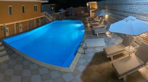una gran piscina con sillas y sombrillas en Valtos Ionion, en Parga