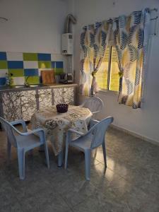 uma mesa e cadeiras numa cozinha com uma mesa e uma janela em Beau duplex Haouaria em El Haouaria