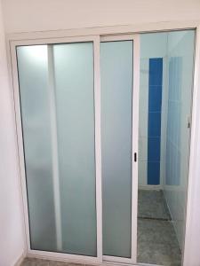 uma porta de vidro deslizante num quarto em Beau duplex Haouaria em El Haouaria