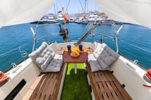 une terrasse en bois avec une table et des chaises sur un bateau dans l'établissement Seaside Chill-out Stay on a Sail Yacht, à Puerto Calero