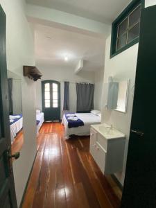 um quarto com 2 camas e piso em madeira em Casa próxima ao centro de convenções da UFOP em Ouro Preto