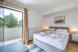 a bedroom with a bed and a large window at Apartments Dado in Poreč