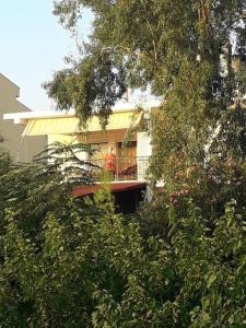 una persona parada en el balcón de una casa en George Geust House en Oropós