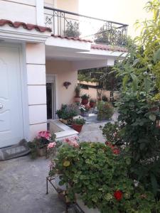 un jardín con flores y plantas frente a una casa en George Geust House en Oropós