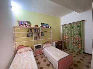 1 dormitorio con 2 camas y estante para libros en La "Piccola della Gioia", en Birgi Vecchi