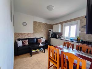 a living room with a black couch and a kitchen at Casa Kores in Icod de los Vinos