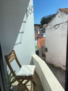 a chair sitting on the balcony of a building at Casa da Amoreira in Odeceixe