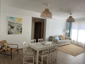 a living room with a white table and chairs at Casa da Amoreira in Odeceixe