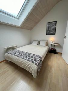 a bedroom with a bed and a skylight at Naturnahe Familienwohnung in Rüschegg-Graben
