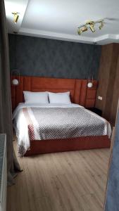 a bedroom with a large bed with a wooden headboard at Lileo in Tsalka